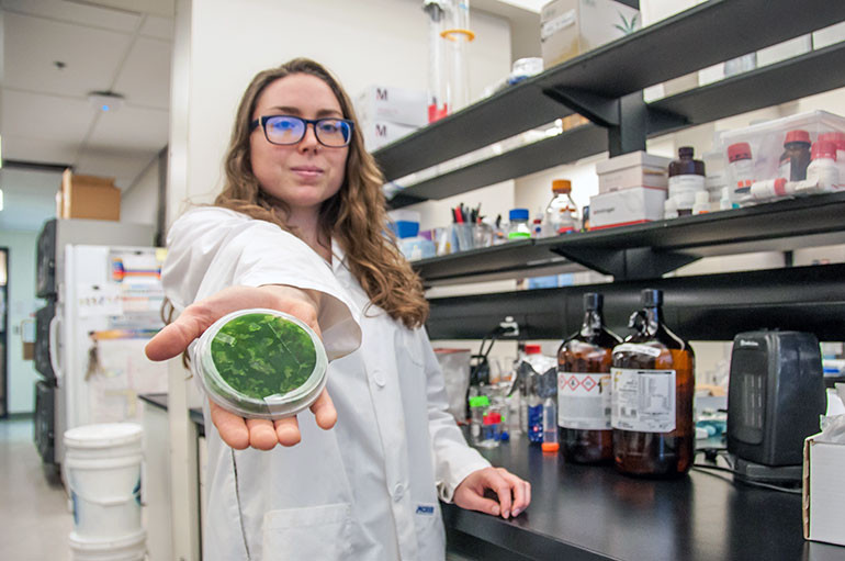 Stephanie Bishop, graduate student in chemistry at UBC Okanagan, holds a sample from Lake Winnipeg